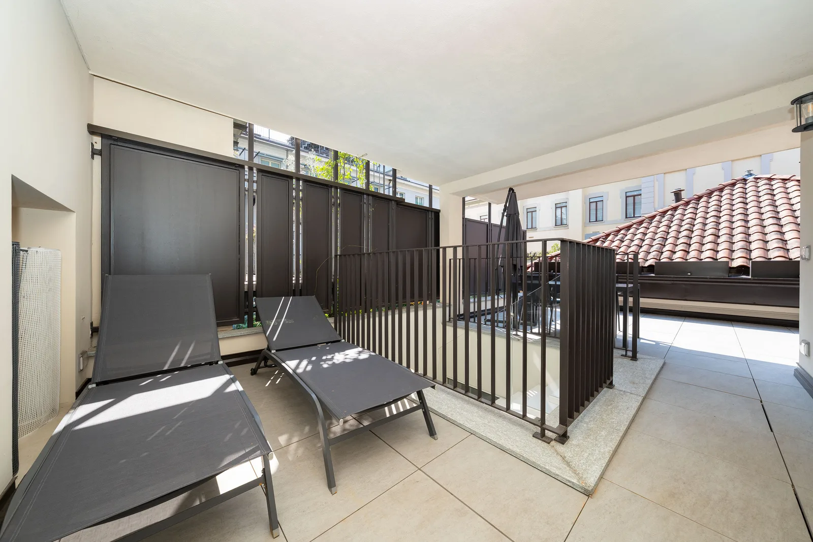 Signature Grand Suite — terrazza privata con lettini prendisole e vista sui tetti di Torino