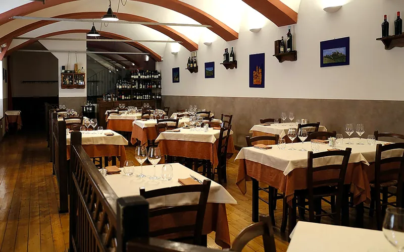 Taverna dell'Oca, Torino — sala accogliente con travi a vista e tavoli apparecchiati