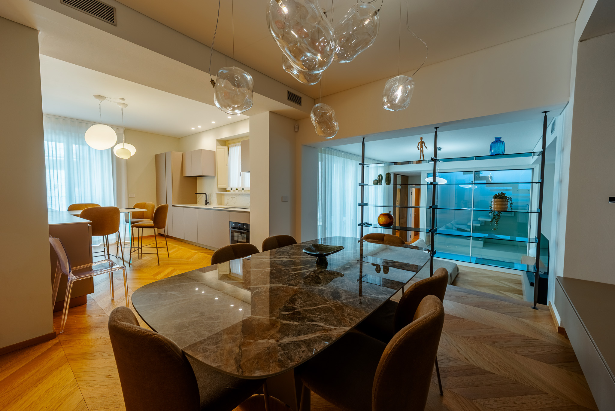 Sala da pranzo e cucina lineare con lampadari in vetro organico