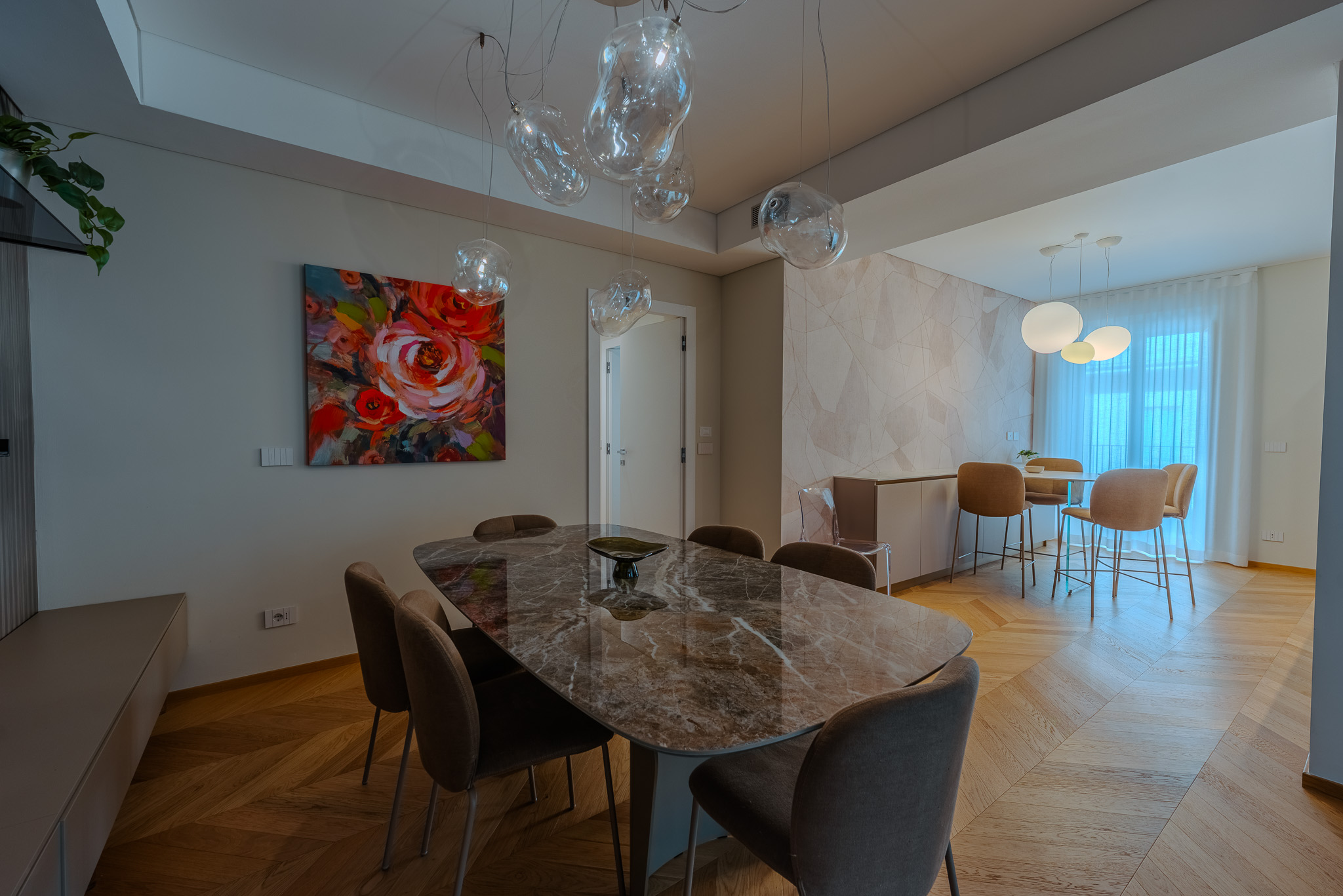 Sala da pranzo con tavolo in marmo grigio e sedie velluto cammello
