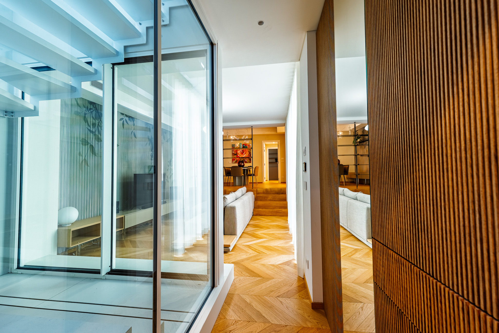 Corridoio in parquet con vista sul bagno in marmo