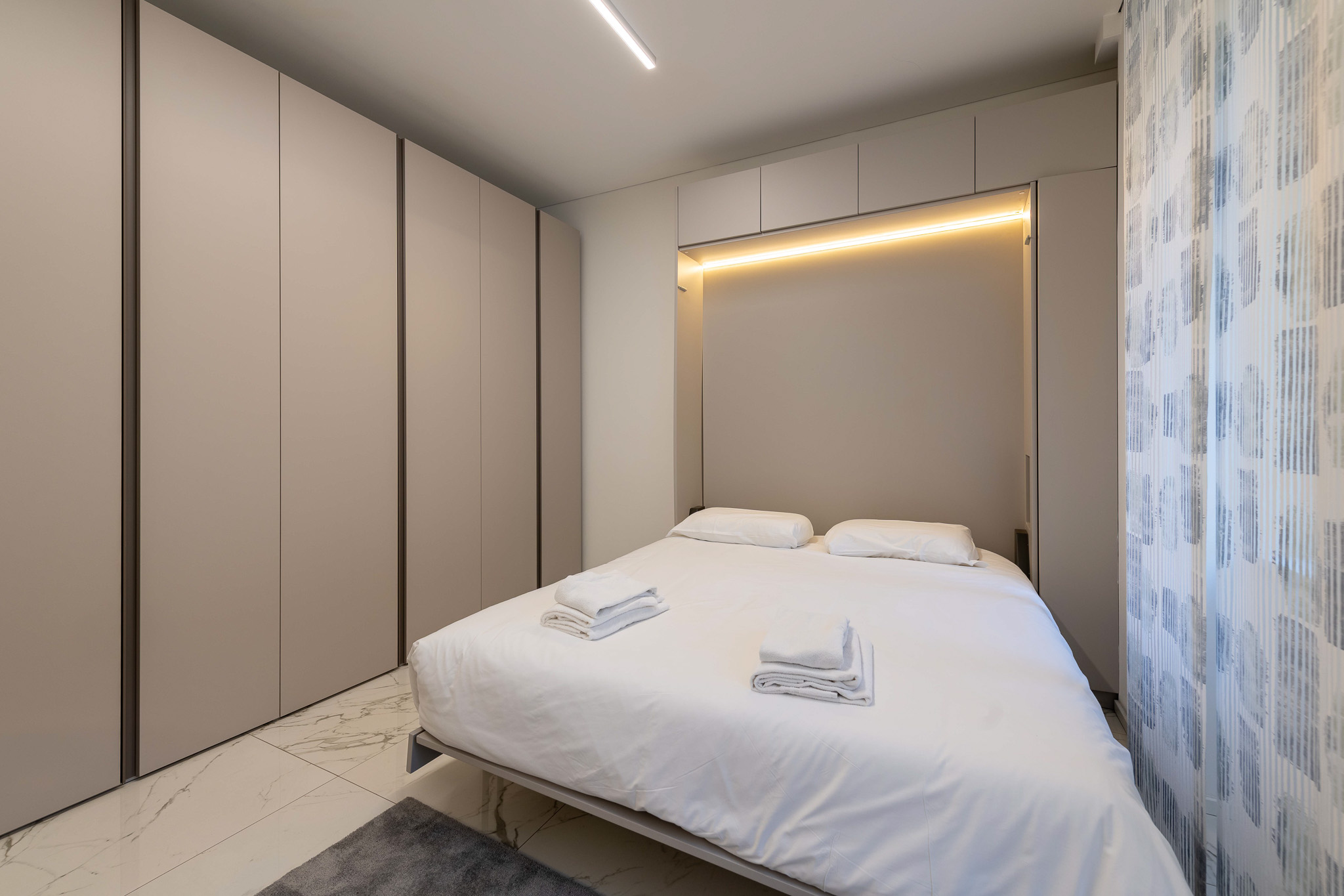 Second bedroom with white built-in wardrobe and LED light