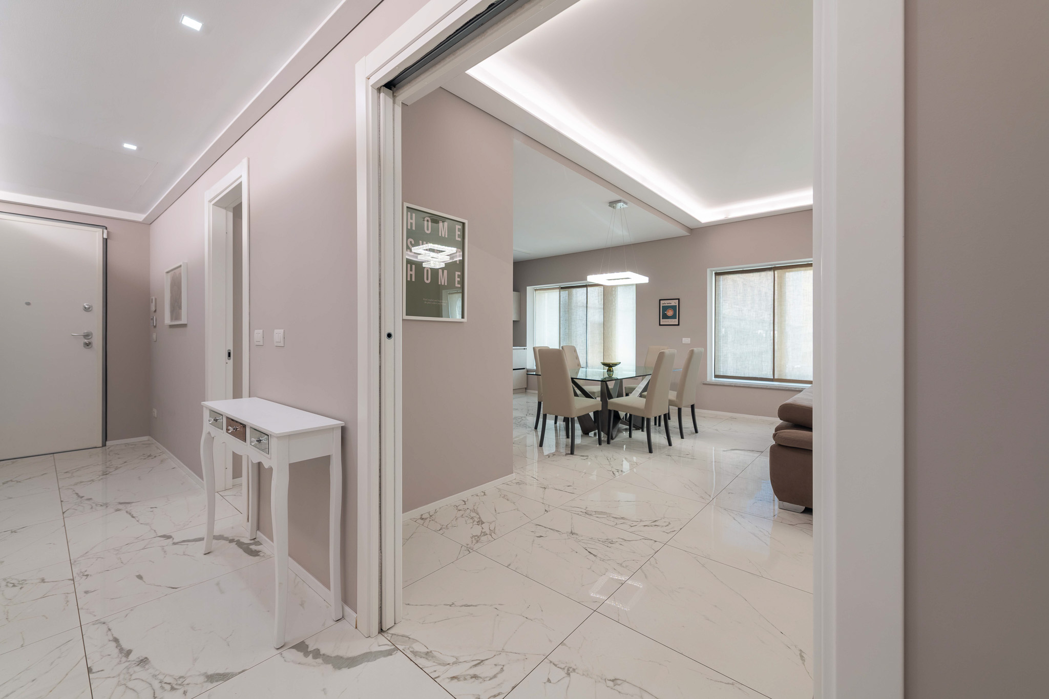 Entrance hall with white carved console and Calacatta marble