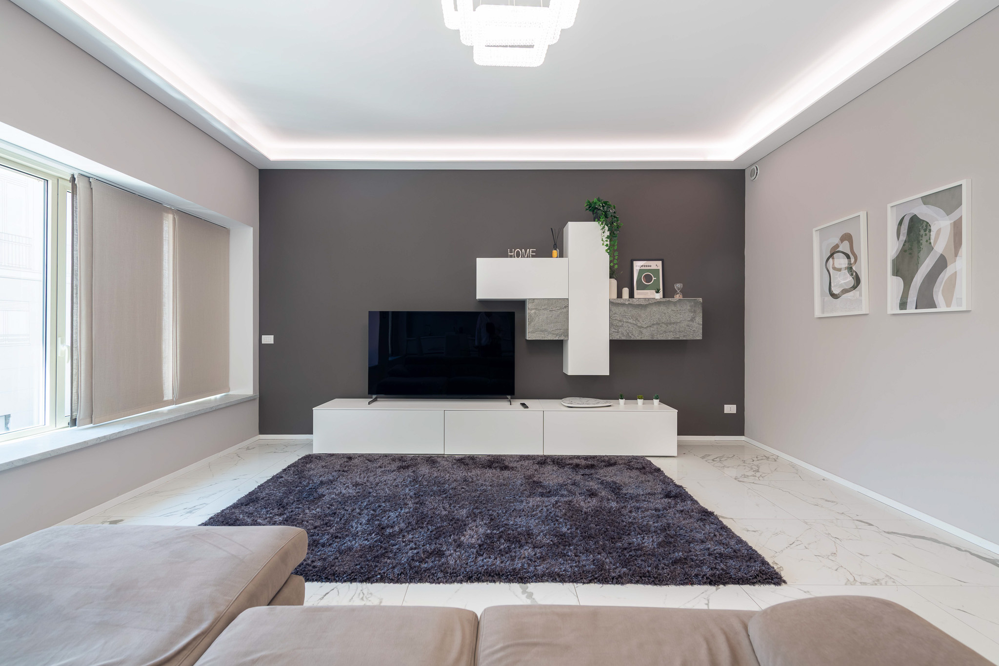 Living room with charcoal wall, TV unit and dark rug