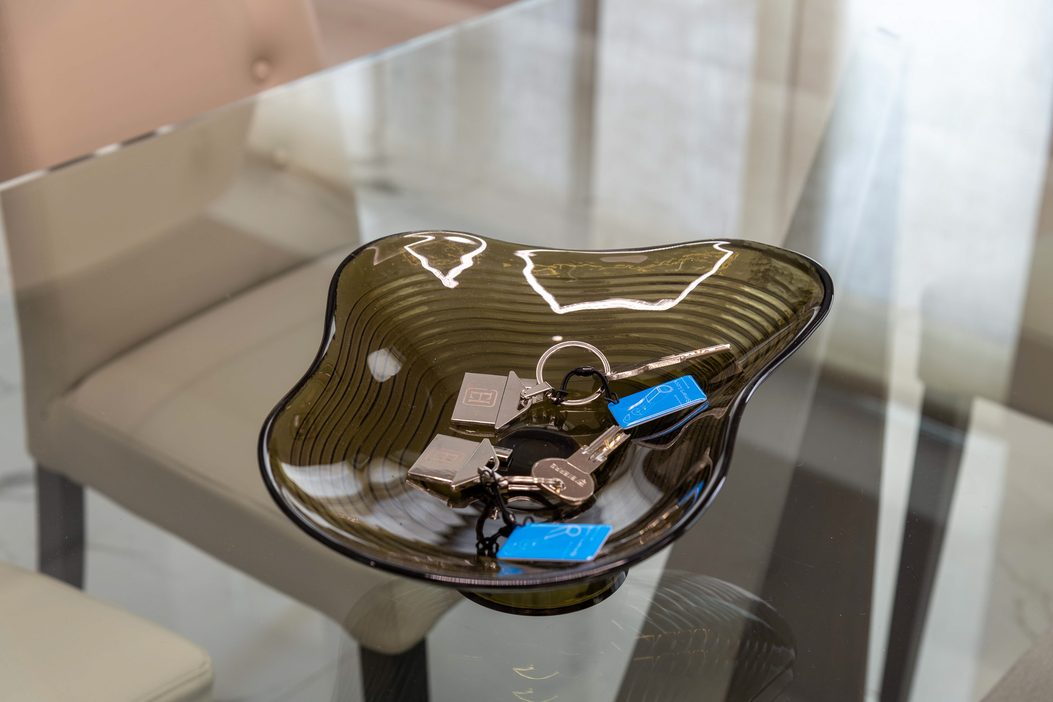 Detail: smoked glass bowl with keys on the glass table