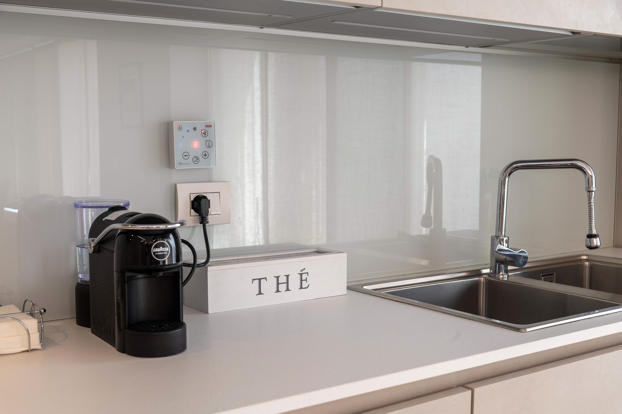 Kitchen detail: espresso machine and stainless steel sink