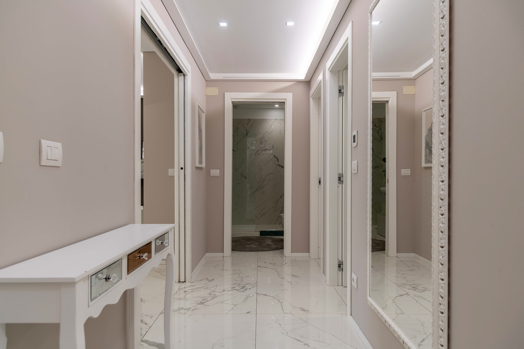 Night hallway with console and access to bathrooms