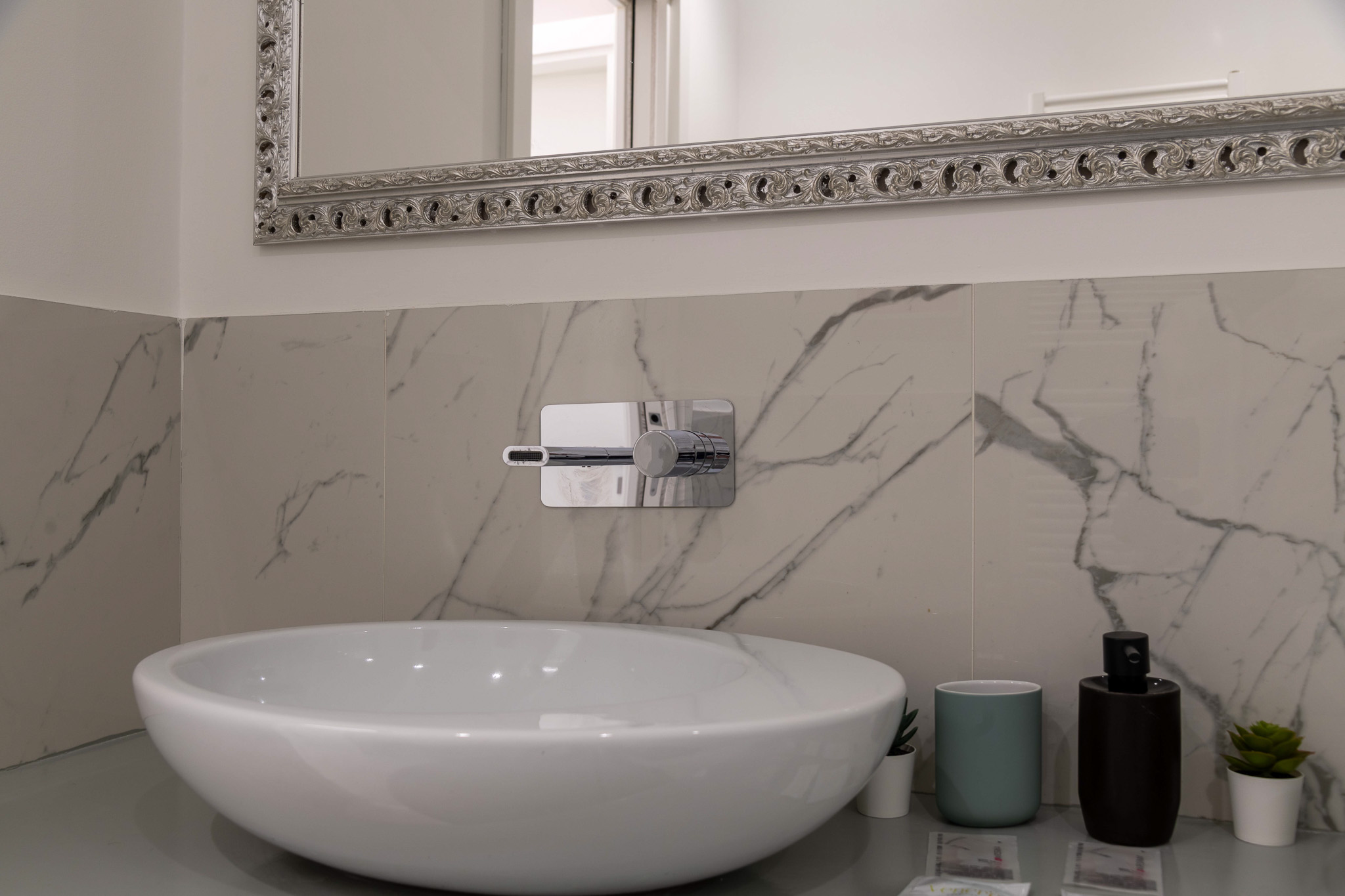 Bathroom detail: vessel sink on marble with mixer tap