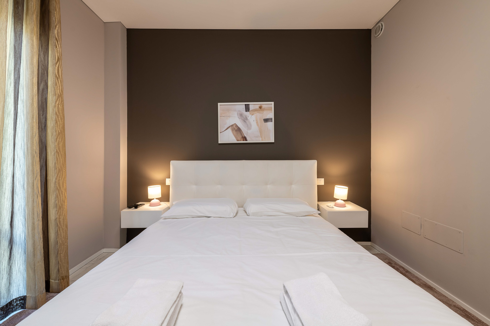 Master bedroom front view, bed with bedside lamps