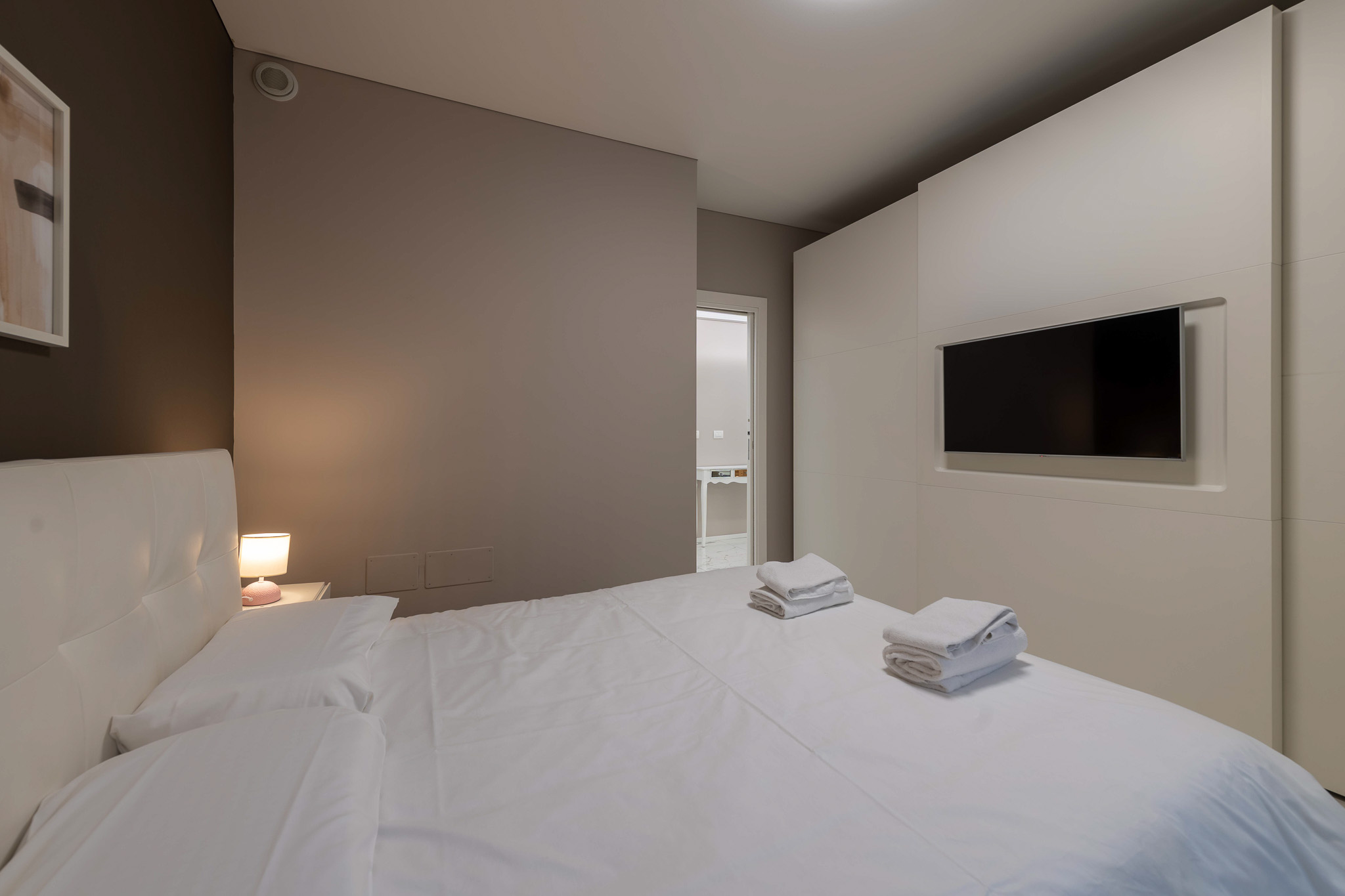 Master bedroom with built-in white wall TV