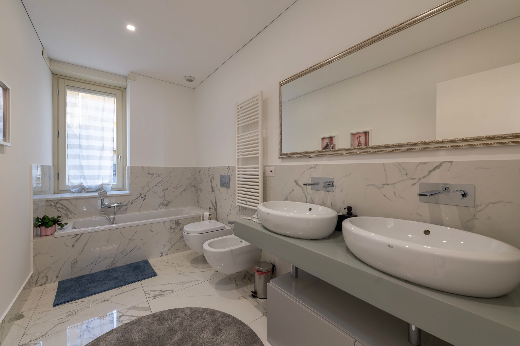 Main bathroom in marble with bathtub and double washbasin